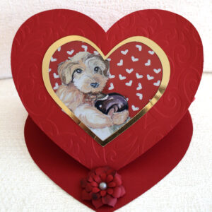 "Be my valentine greeting card " is a heart shaped greeting card featuring the painting by EW. Movileanu of a watercolor puppy holding a sweet donut.